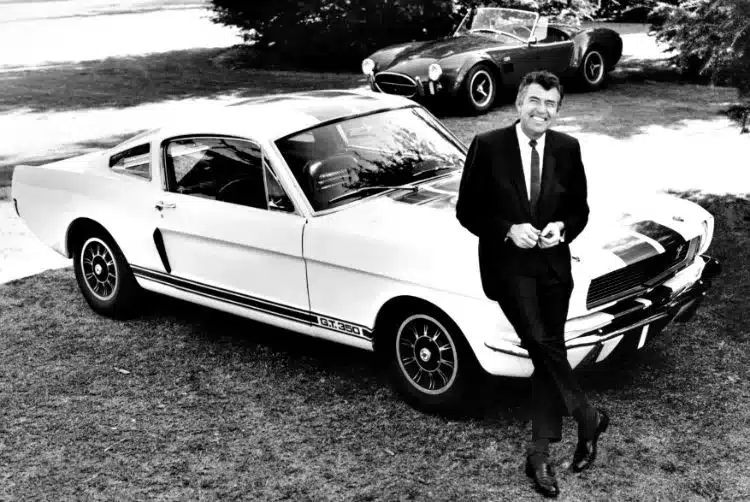 Carroll Shelby die voor een GT350 staat